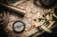 Picture of nautical charts, compass and a sextant.